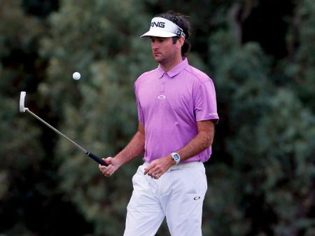 Bubba Watson in a pink t-shirt caught at the camera on a golf-court.